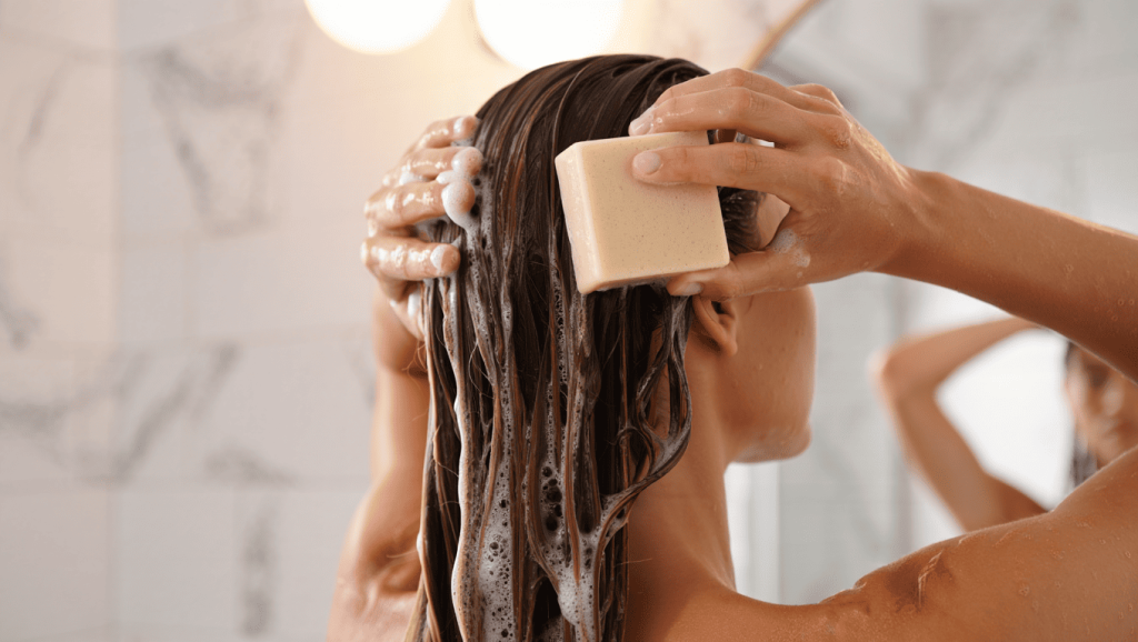 Une femme utilise du shampoing solide